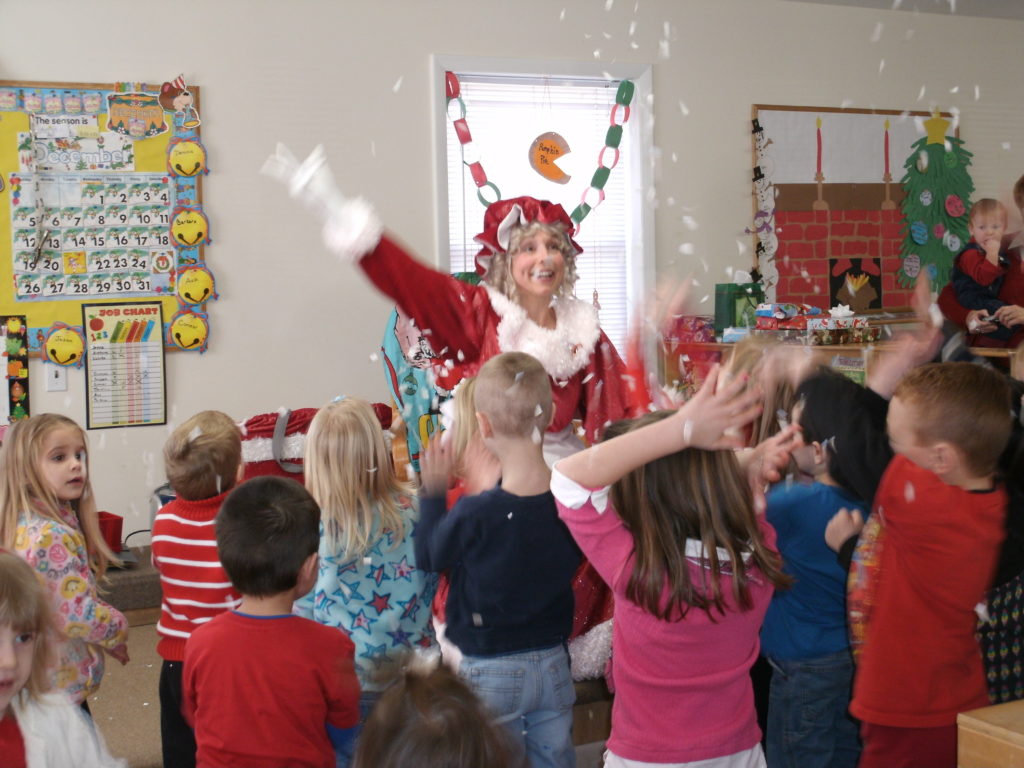 Mrs. Santa tosses confetti snowflakes..