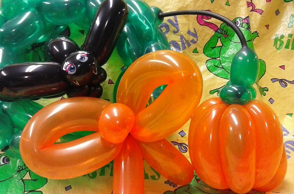 Halloween balloons: Orange pumpkin, black bat and orange bow.