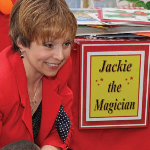 Jackie the Magician greets the audience with a smile.